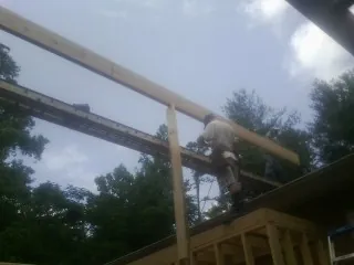 Carpenter setting a ridge beam over a new addition frame — Ice Dam Removal by Roofing Brothers in Factoryville