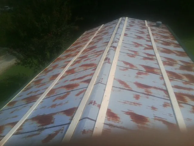 Rusted metal roof panels with new wood purlins before replacement — Storm Damage Roof Repair in Factoryville by Roofing Brothers