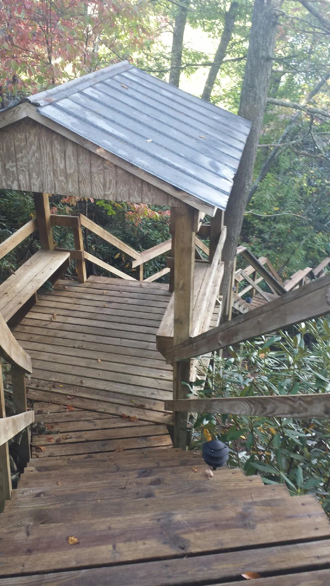 Metal roofed shelter over wooden steps on a wooded walkway — Skylight Repair & Installation work by our crew in Factoryville