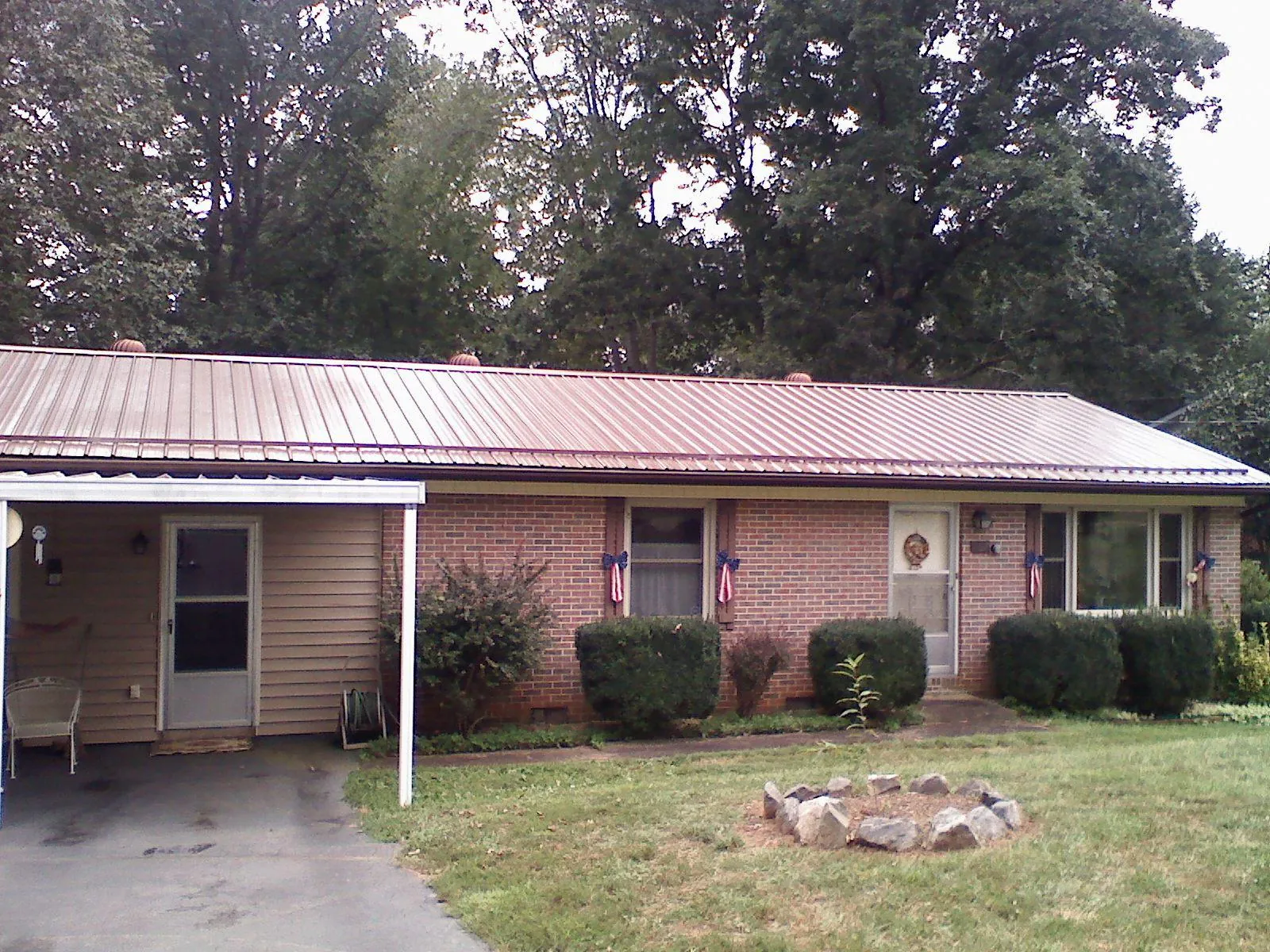 Bronze metal roof and carport on a brick ranch home — Roof Repair work by our crew in Factoryville